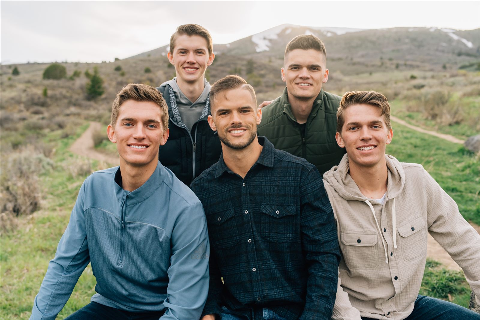 Professional portrait of the five West brothers on a hillside