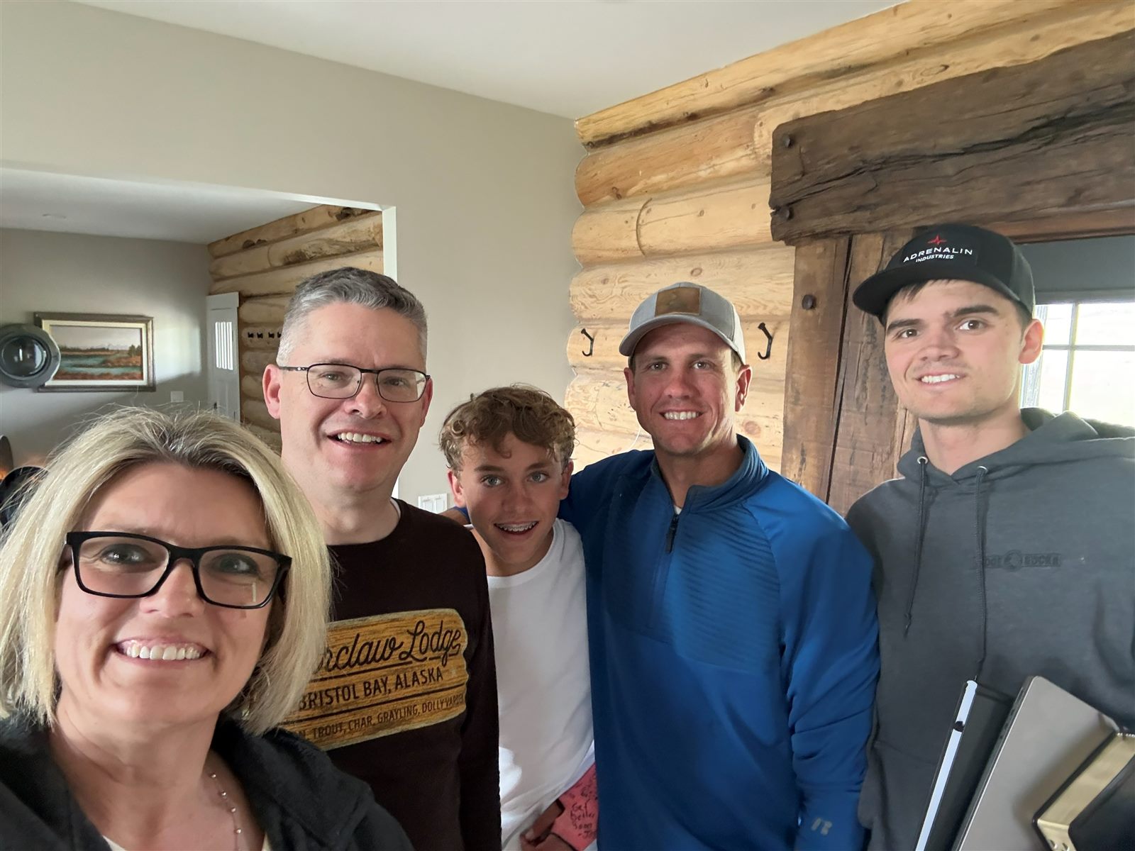 Family selfie inside the log cabin with Caden at the right, notebooks in hand