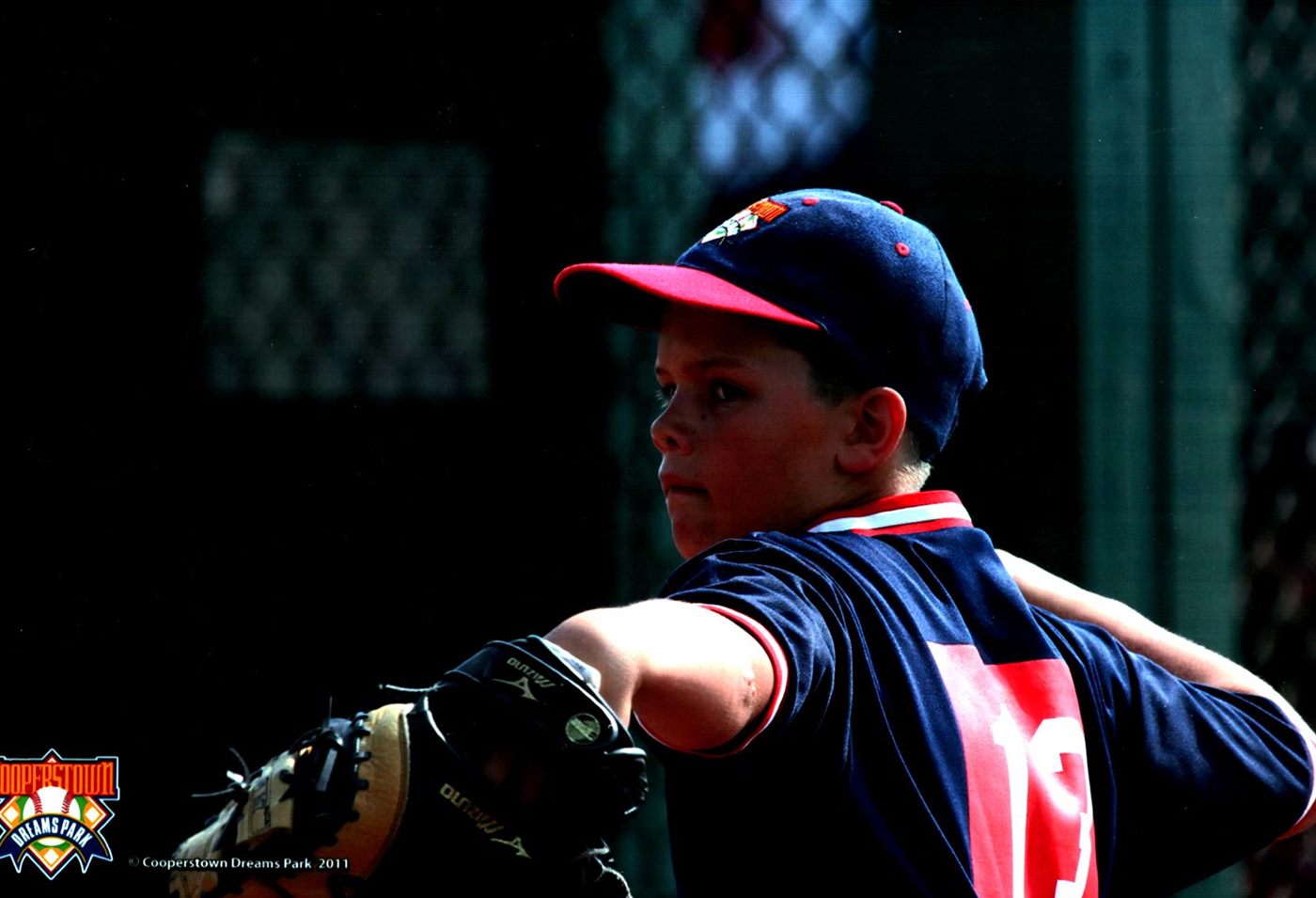 Sunlit action photo of Caden in uniform at Cooperstown Dreams Park
