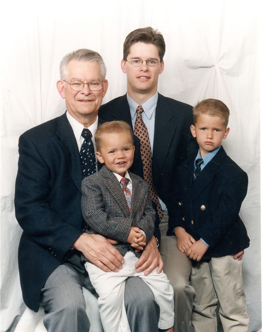 Grandfather, father, and two young boys in Sunday best