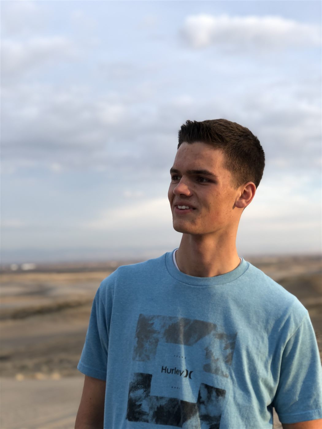 Caden in golden evening light overlooking a desert valley