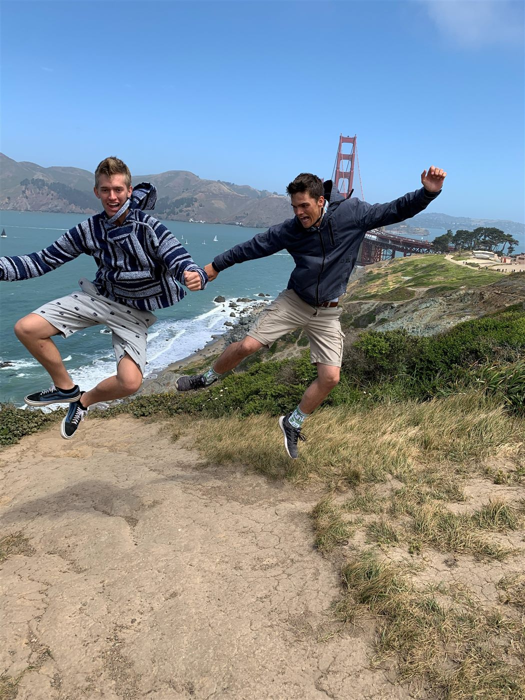 Caden and his brother leaping in the air in front of the Golden Gate Bridge