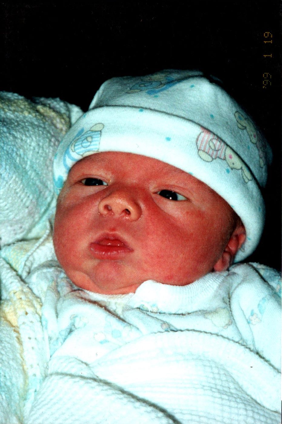 Newborn Caden in a tiny teddy-bear cap, three days old